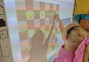 Dziewczyna wykonuje zadania na tablicy interaktywnej